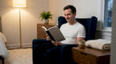 Man reading peacefully in softly lit living room
