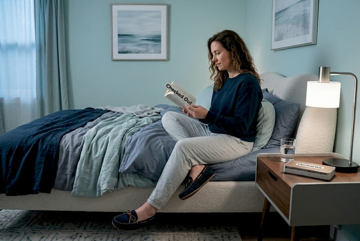 Woman reading in cozy evening bedroom