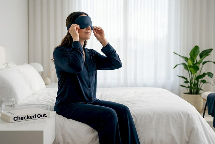 Woman putting on sleep mask in bedroom