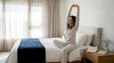 Person stretching in bright peaceful bedroom