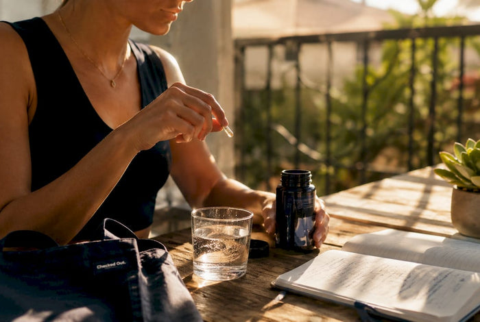 Woman taking vitamin B6 B12 supplement at kitchen table