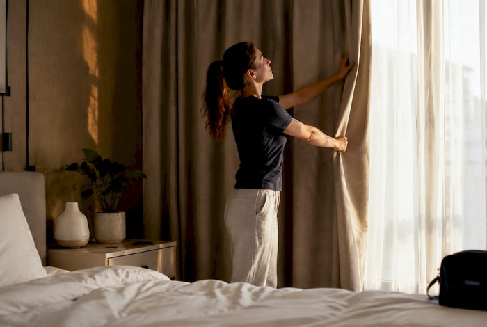 Traveler adjusting curtains in hotel room
