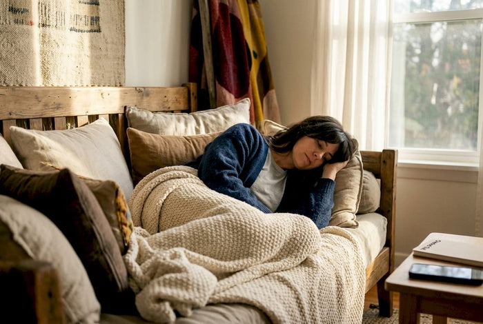 Woman arranging pillows on cozy canopy bed