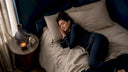 Woman preparing to fall asleep in cozy bedroom