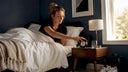 Woman setting alarm clock beside bed in bedroom