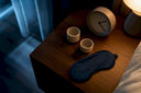 Dosing cups beside a bedside clock